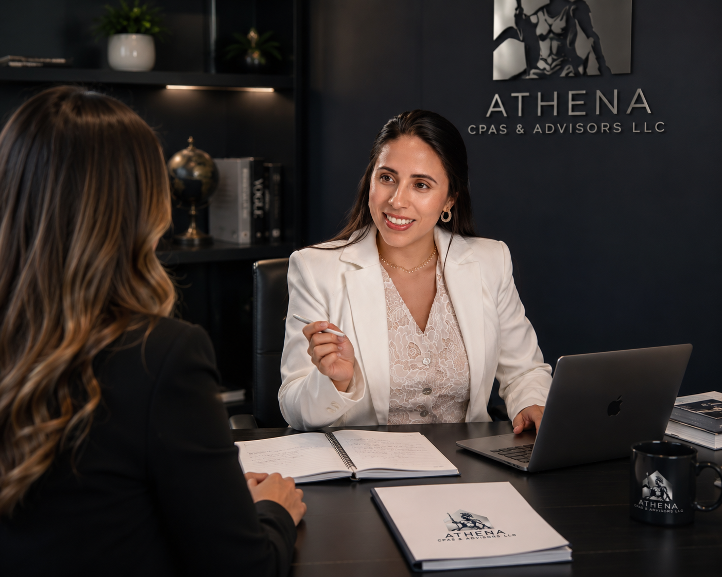 Laura Zarrate, CPA, founder of ATHENA CPAs & Advisors, meeting with a client at her desk